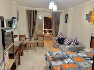 a living room with two couches and a tv at Aqua view north cost-pool view studio with amazing terrace in Al Qaşabah ash Sharqīyah
