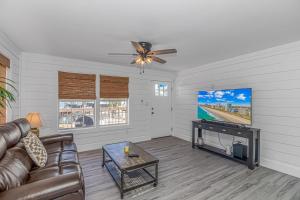 a living room with a couch and a flat screen tv at Beachside Retreat - Garden City - Murrells Inlet in Myrtle Beach