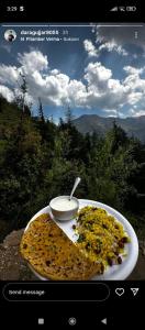 uma fotografia de um prato de comida com uma tigela de molho em Forest View Cottage em Jibhi