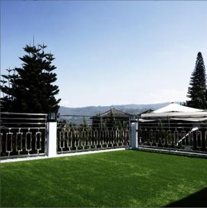 einen Zaun mit grünem Gras im Hof in der Unterkunft Villa Arundaya Kota Batu in Punten
