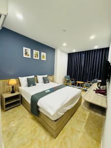 una camera con un grande letto con una parete blu di Like Hotel ad Ho Chi Minh