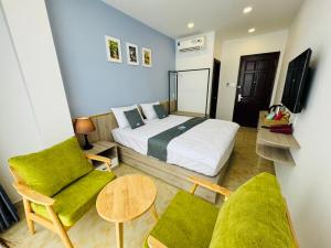 a bedroom with a bed and two chairs and a table at Like Hotel in Ho Chi Minh City