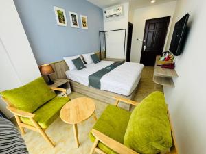 a bedroom with a bed and two chairs and a table at Like Hotel in Ho Chi Minh City