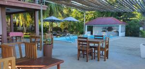 un patio con mesa, sillas y cenador en Nosy Bay View, en Nosy Be