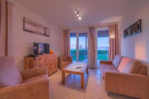 ein Wohnzimmer mit zwei Sofas und einem Fernseher in der Unterkunft Gartendeck 431 in Rechlin