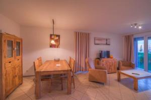 ein Wohnzimmer mit einem Tisch und ein Esszimmer in der Unterkunft Gartendeck 431 in Rechlin + 2 Fotos