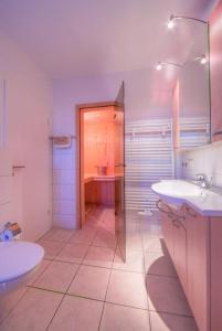 ein weißes Badezimmer mit zwei Waschbecken und einer Dusche in der Unterkunft Gartendeck 431 in Rechlin