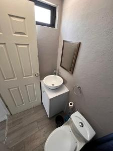 een badkamer met een wit toilet en een wastafel bij KAVA lofts in El Pueblito