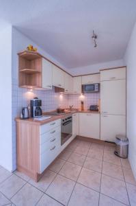 una cocina con armarios blancos y electrodomésticos blancos en Gartendeck 471, en Zielow