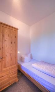 1 dormitorio con 1 cama y armario de madera en Gartendeck 471, en Zielow