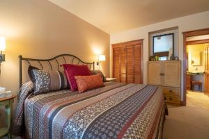 um quarto com uma cama grande e almofadas coloridas em Palmyra 3D by AvantStay Gorgeous Condo in Great Location em Telluride