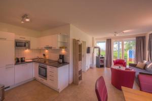 a kitchen and living room with a couch and a table at Gartendeck 532 in Rechlin