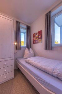 a bedroom with a bed and two windows at Gartendeck 532 in Rechlin
