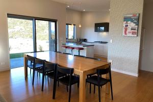 a kitchen with a wooden table and black chairs at The Yellow Door in Wanaka