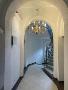 a hallway with a chandelier and a staircase at Ferienwohnung Zimmermann in Bad Schandau