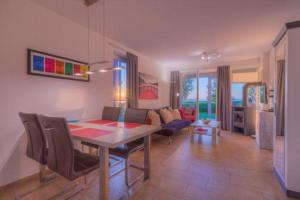 a dining room and living room with a table and chairs at Gartendeck 531 in Rechlin
