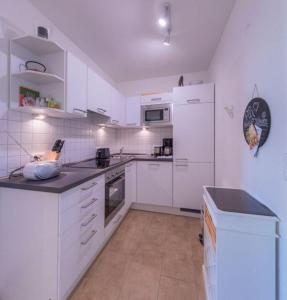 a white kitchen with white appliances and white cabinets at Gartendeck 531 in Rechlin +7 photos