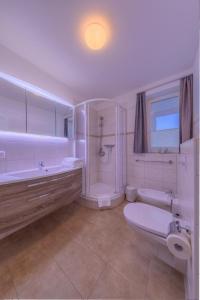 a white bathroom with a tub and a toilet and a sink at Gartendeck 531 in Rechlin