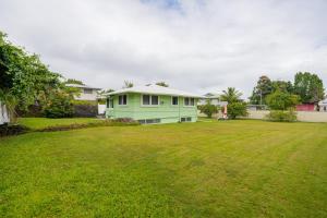 a green house in the middle of a yard at Hale Leilani - Hilo 3BR cold AC in Hilo