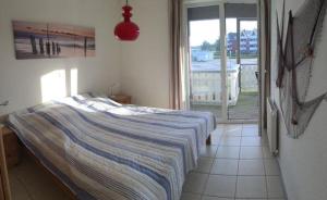 ein Schlafzimmer mit Bett und Blick auf einen Balkon in der Unterkunft Mitteldeck 414 in Rechlin