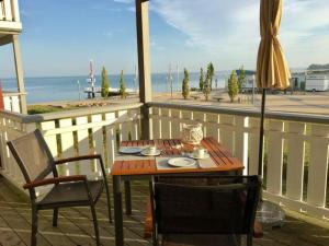 einen Tisch, Stühle und einen Regenschirm auf dem Balkon in der Unterkunft Mitteldeck 414 in Rechlin