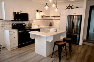 a kitchen with white cabinets and a black refrigerator at Alma 2 bedroom Sleeps 6 in Alma