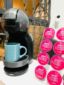 a coffee maker with a blue cup on a counter at Center Hostel Sp in Sao Paulo