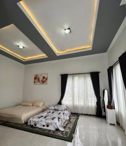 ein Schlafzimmer mit einem Bett und einer Kassettendecke in der Unterkunft Villa Arundaya Kota Batu in Punten