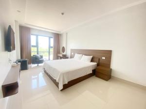 1 dormitorio con cama, escritorio y silla en Khách sạn Phú Hưng, en Thái Nguyên