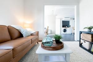 ein Wohnzimmer mit einem Sofa und einem Tisch in der Unterkunft Comfortable Urban Cottage with Parking in Launceston