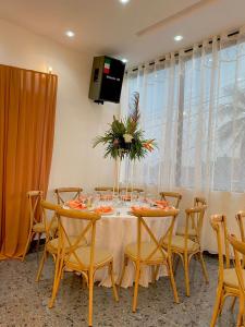 une salle à manger avec une table, des chaises et une télévision dans l'établissement SAPHYR GROUP HOTELIER, à Douala