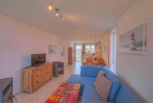 a living room with a blue couch and a tv at Mitteldeck 523 in Rechlin