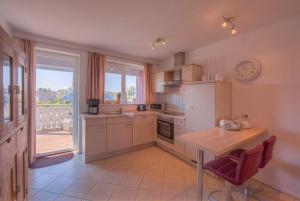 a kitchen with a counter and a table with chairs at Mitteldeck 523 in Rechlin +9 photos