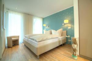 a bedroom with a large bed with a blue wall at Penthouse 211 in Zielow