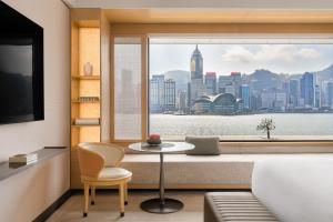 Habitación con mesa y ventana con vistas a la ciudad. en Regent Hong Kong, en Hong Kong