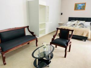 バーニョスにあるCasa Gaviota Doradaのベッドルーム1室(ベッド1台、椅子2脚、ガラステーブル付)