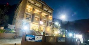 un edificio di notte con luci davanti di Goroomgo Park Paradise Manali - Elevator Lift & Parking Facilities a Manāli