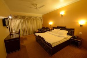 una camera da letto con un grande letto con lenzuola bianche di Goroomgo Park Paradise Manali - Elevator Lift & Parking Facilities a Manāli