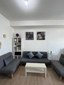 Una sala de estar con dos sofás y una mesa de café. en Vinia Infinity Studio 1 Near Malls with WiFi and Netflix, en Manila