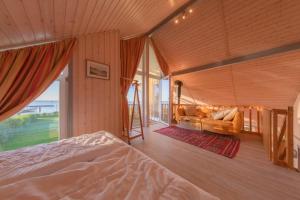 a bedroom with a bed and a couch and a window at Wildgans Classic 29 in Rechlin