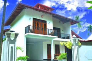 a white house with a balcony at Hannaford House Bentota in Bentota