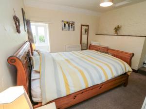 Hawsker的住宿－Abbey View Cottage，一间卧室配有带条纹毯子的床
