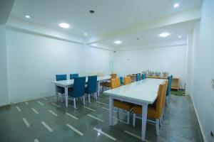 ein leeres Zimmer mit Tischen und Stühlen darin in der Unterkunft Airport Grand Travel Inn in Neu-Delhi