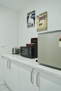 un comptoir de cuisine avec un micro-ondes et une pancarte sur le mur dans l'établissement Kingfisher Studio, à Lac Tekapo