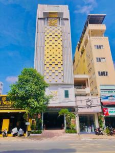 a tall yellow building with a clock on it at Miền Tây Hotel in Can Tho