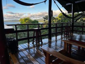 een houten terras met uitzicht op het water bij Nativos Corcovado cabins in Drake