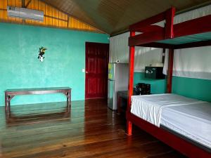 a bedroom with two bunk beds and a red door at Nativos Corcovado cabins in Drake