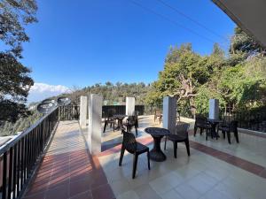 a patio with tables and chairs on a balcony at Hotel Canadian forest view in Dalhousie
