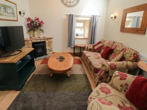 a living room with a couch and a tv at Barn Cottage in Whitby