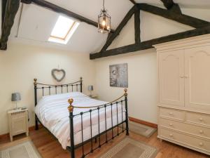 a bedroom with a bed and a dresser at Barn Cottage in Whitby